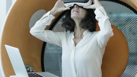 Woman-using-laptop-and-vr-headset